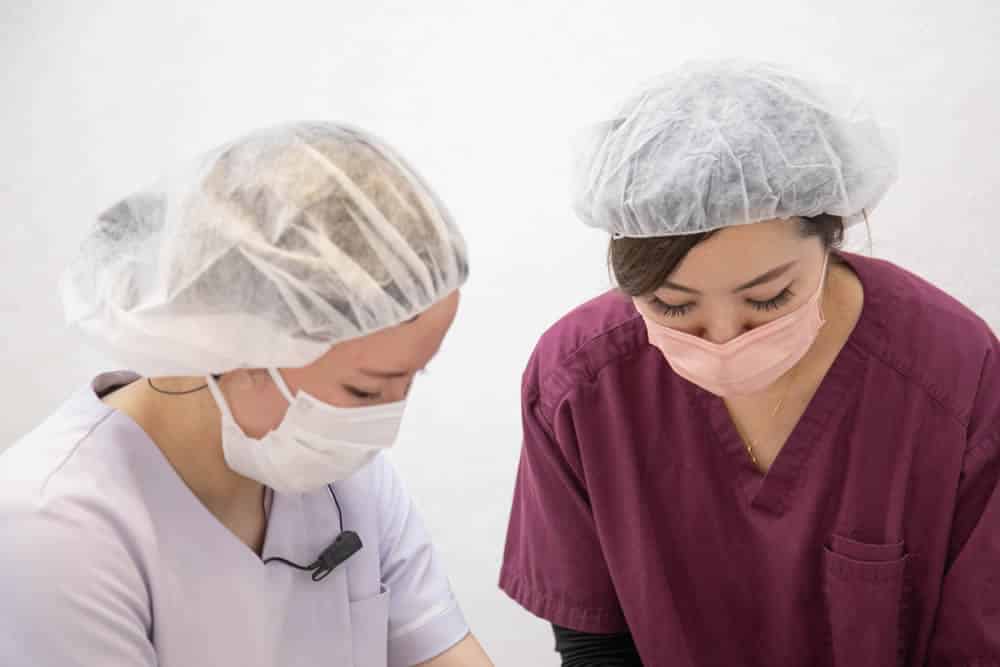 後輩に仕事を教えている看護師